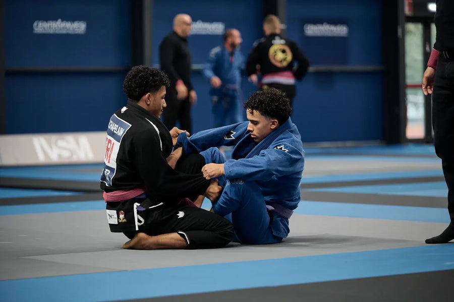 Combat au sol en compétition de JJB, kimono noir contre kimono bleu