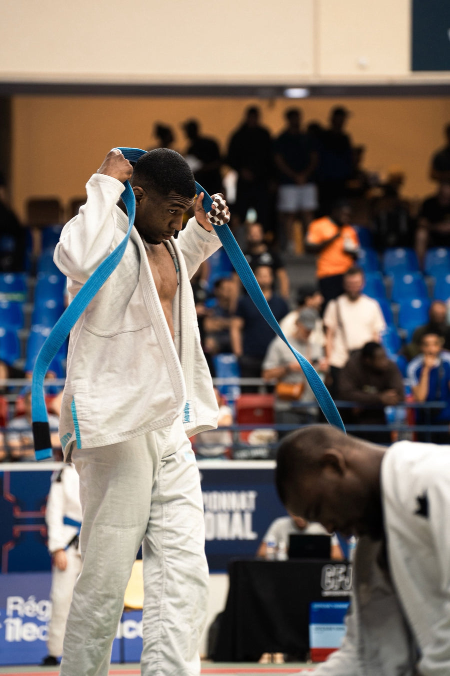 Combattant en kimono blanc qui s'échauffe avec sa ceinture bleue