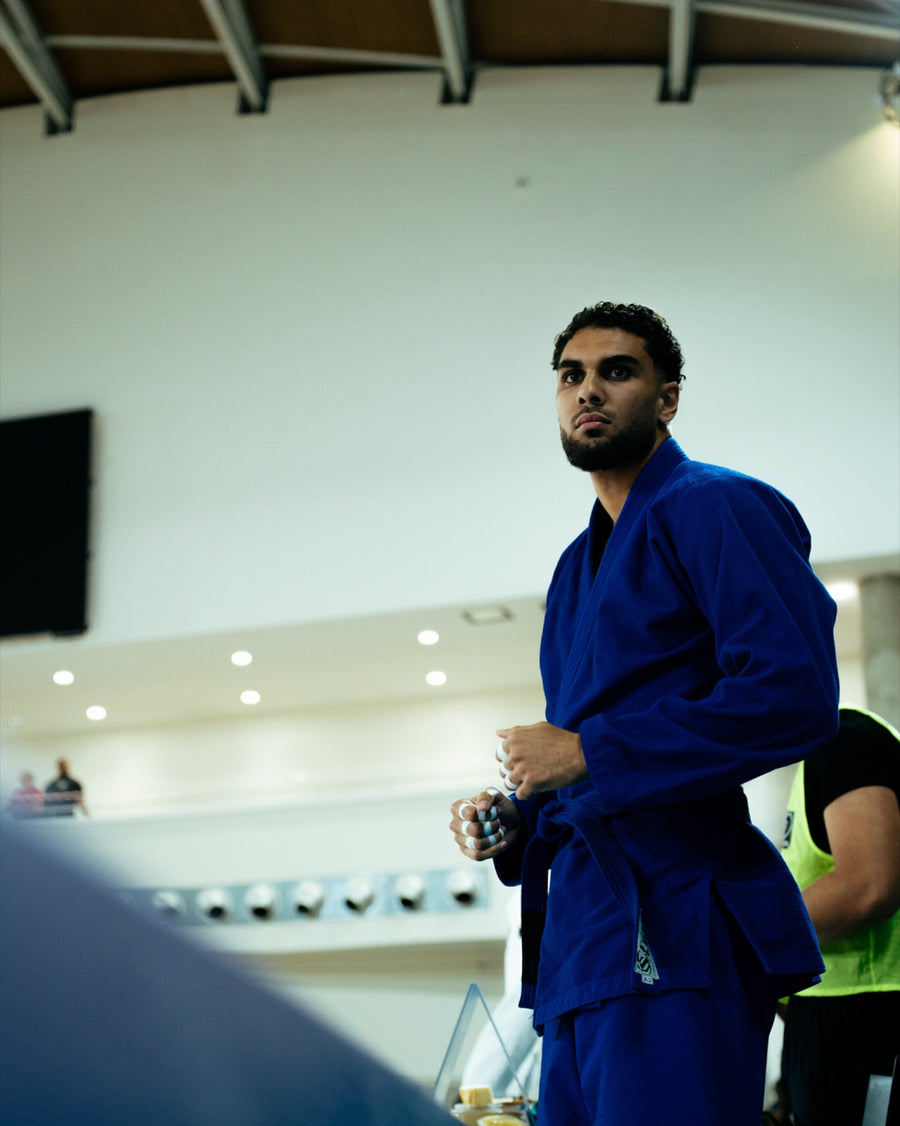 Combattant de JJB en kimono bleu concentré avant son combat