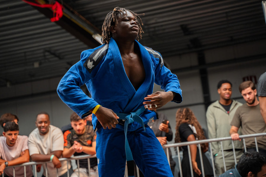 Combattant de JJB en kimono bleu, doigts protégés par du finger tape