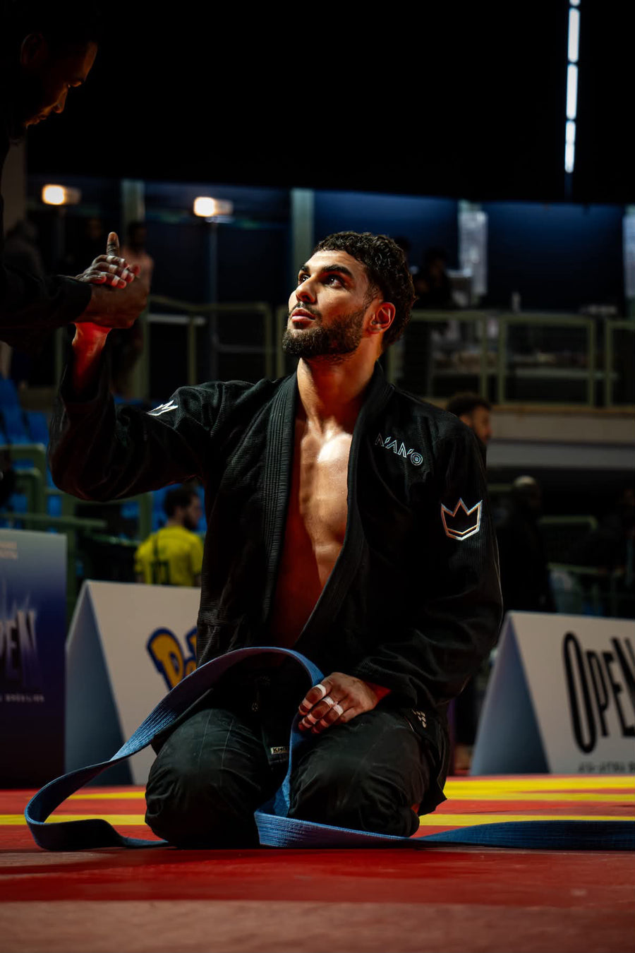 Combattant à genoux sur le tatami, doigts tapés