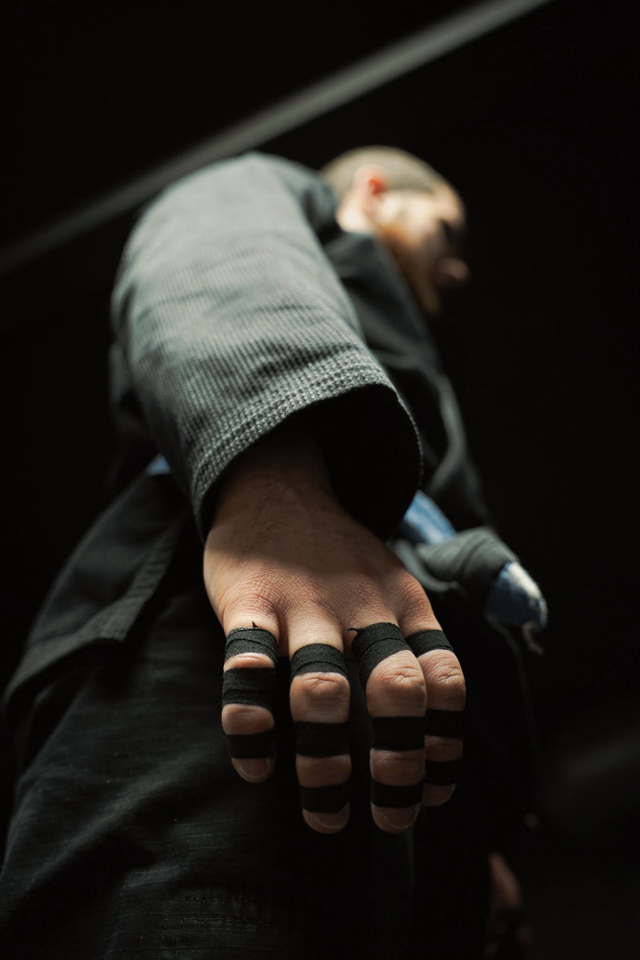Gros plan sur une main aux doigts tapés avec du finger tape noir