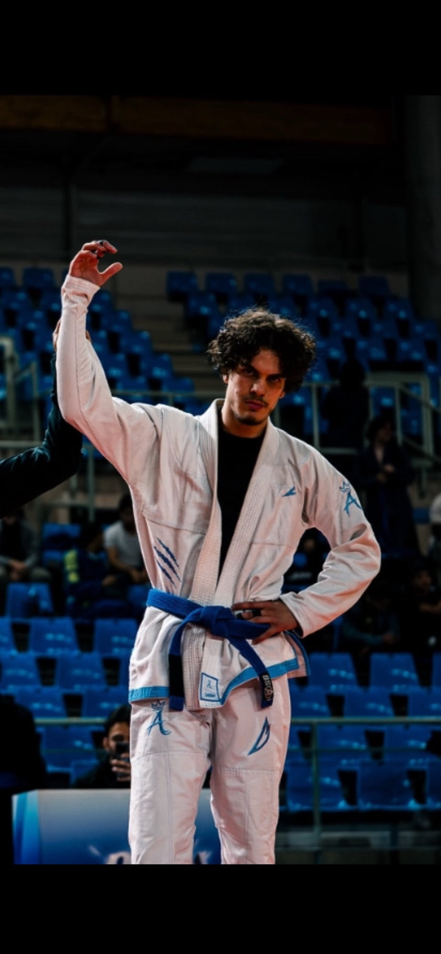 Combattant en kimono blanc ceinture bleue qui célèbre sa victoire