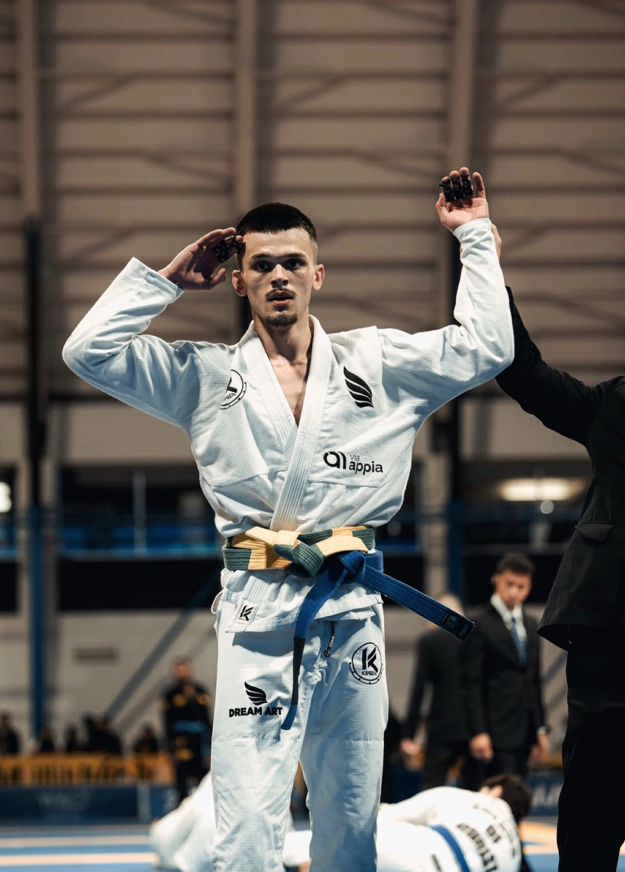 Combattant en kimono blanc qui salue après sa victoire, doigts tapés